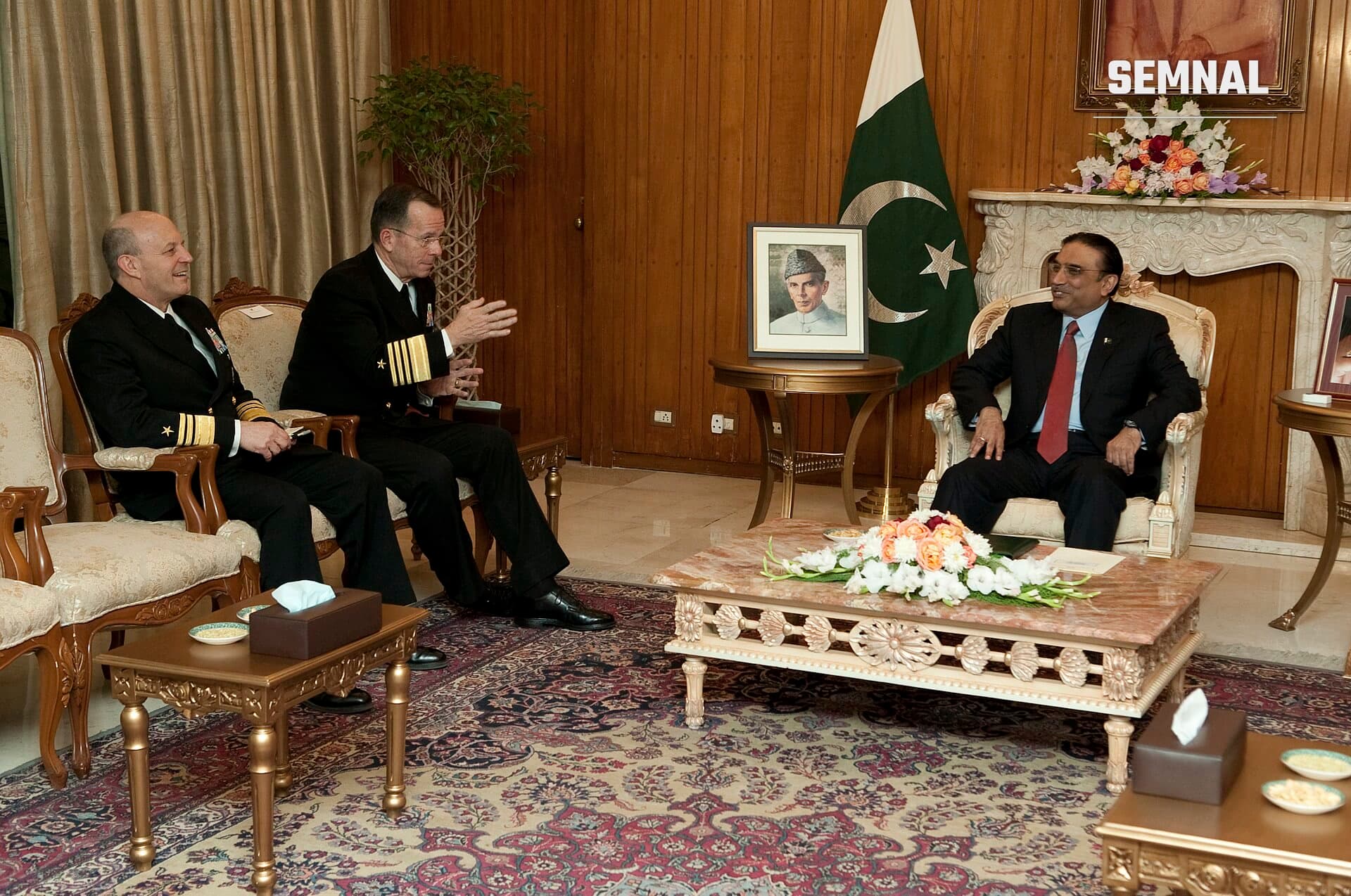 Asif Ali Zardari în prim-plan, ședindu-se pe scaun oficial în interiorul unui salon elegant, cu steagul Pakistanului în fundal. (Foto: Chad J. McNeeley (U.S. armed forces))