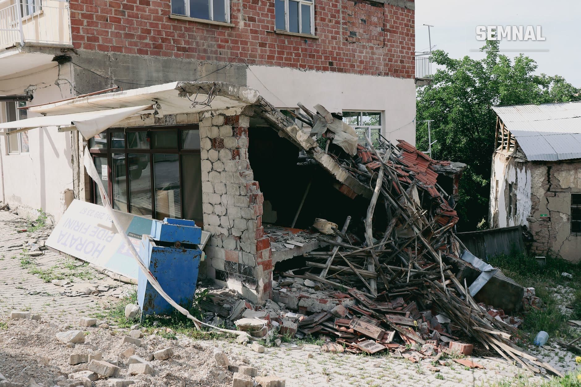 Clădire grav deteriorată cu acoperiș și pereți parțial prăbușiți, moloz de cărămidă și lemn dispers pe sol dezgolind structura internă a construcției. (Foto: Serkan Gönültaș / Pexels)