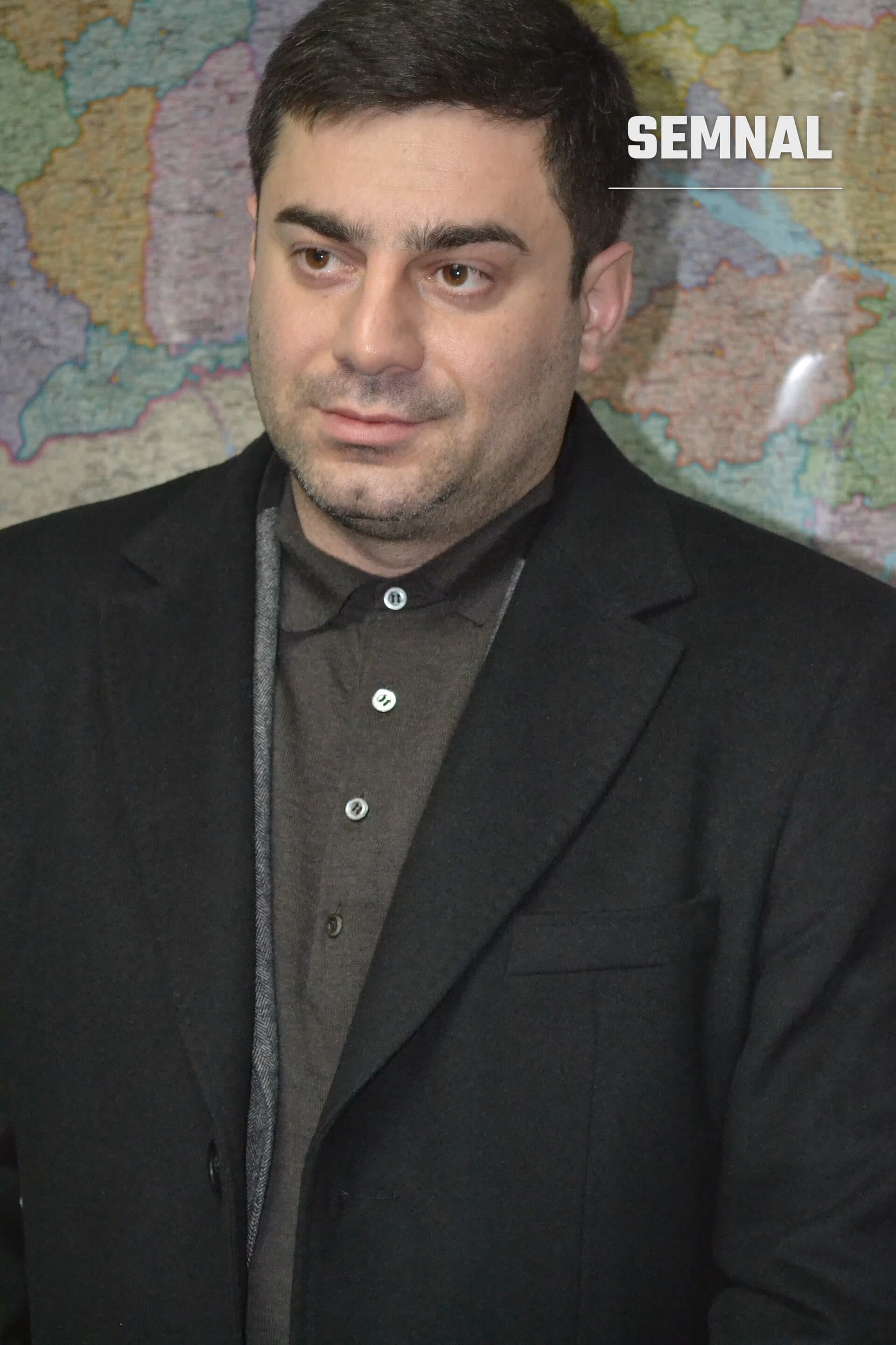 Dmytro Lubinets, comisarul pentru drepturile omului al Radei Supreme, într-un sacou negru, în fața unei hărți politice colorate. (Foto: Ivasykus)