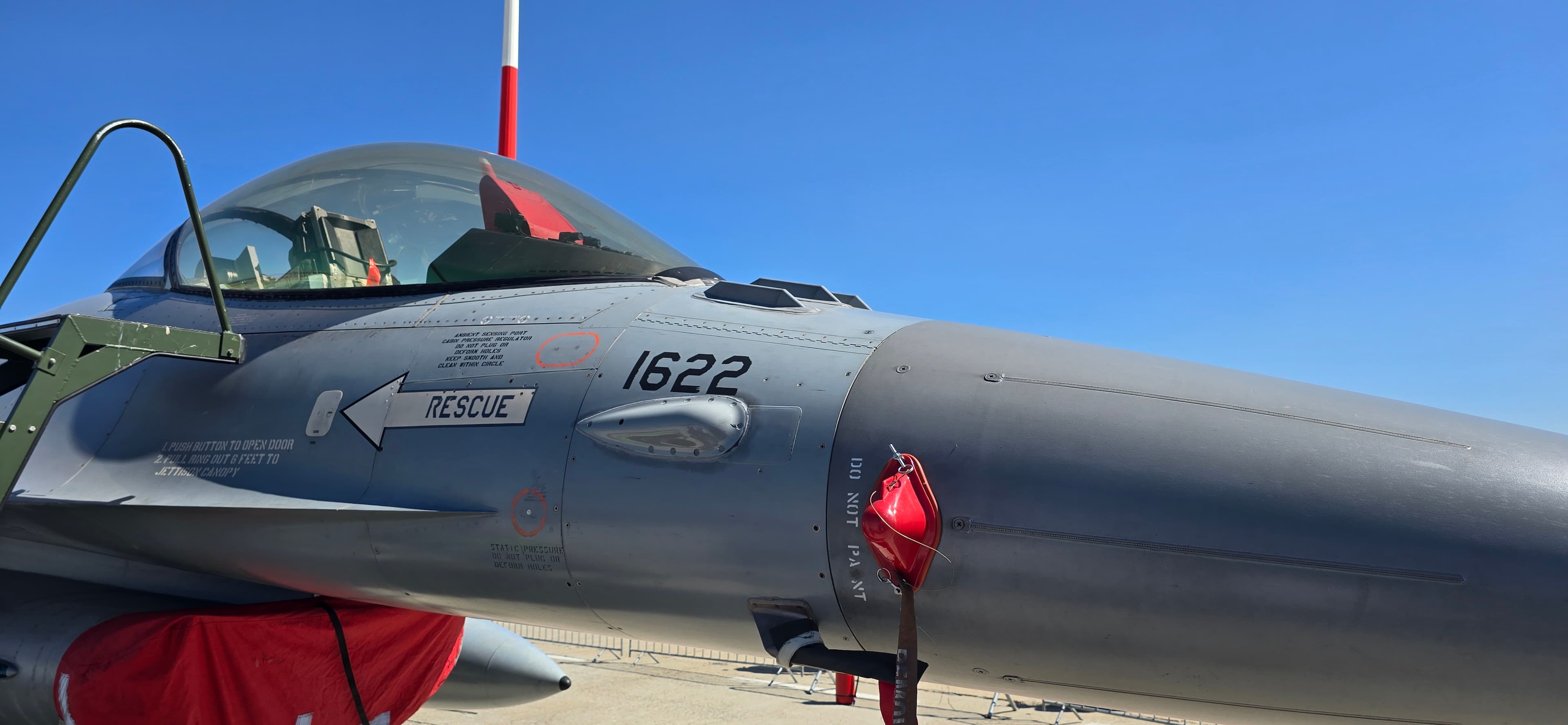 Partea din față a unui avion de vânătoare F-16 al Forțelor Aeriene Române, cu numărul de bord 1622, staționat pe platformă cu protecții roșii de siguranță montate