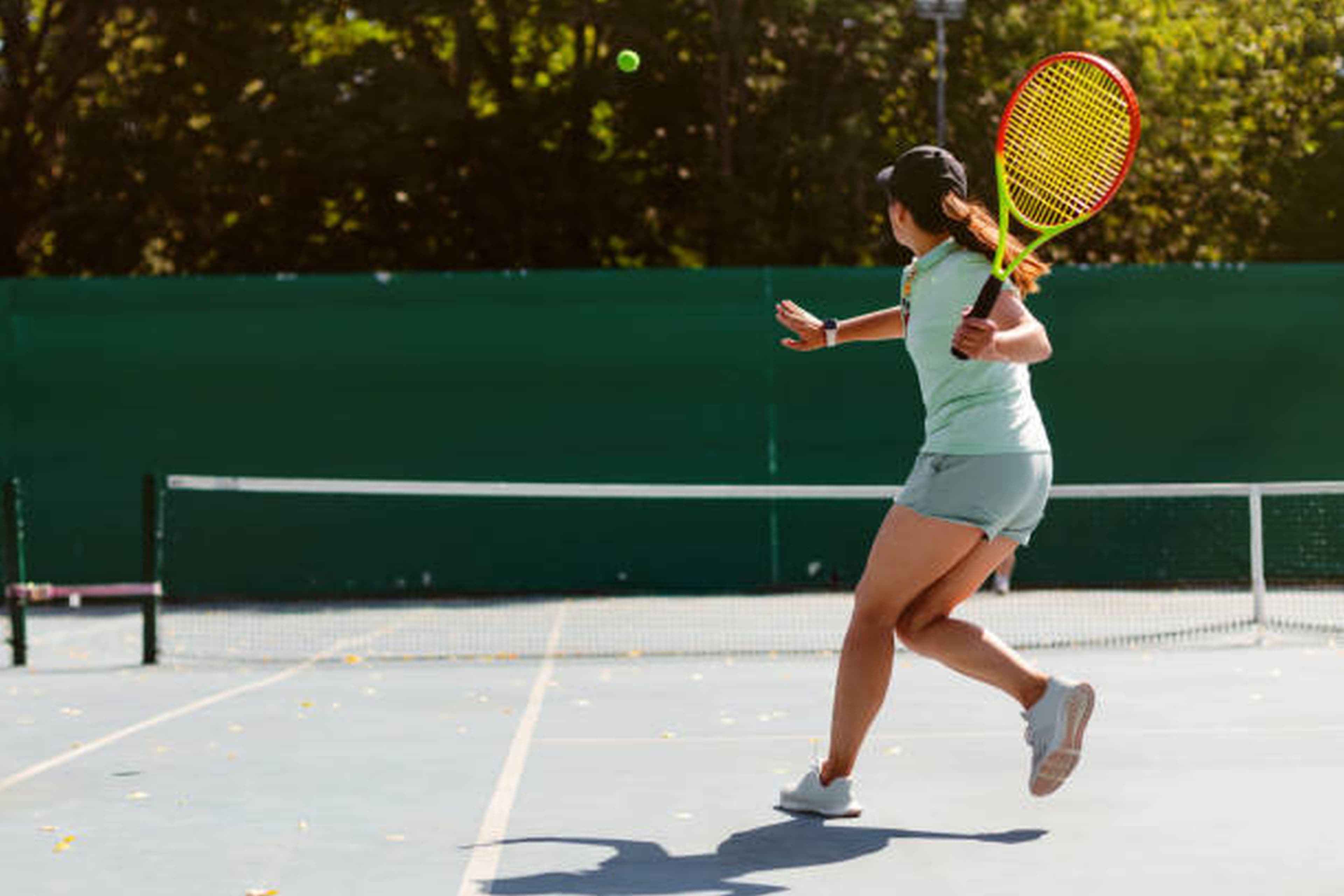 Jucătoare de tenis lovind mingea pe un teren de zgură, imagine simbolică pentru un articol despre suspendarea lui Nick Kyrgios