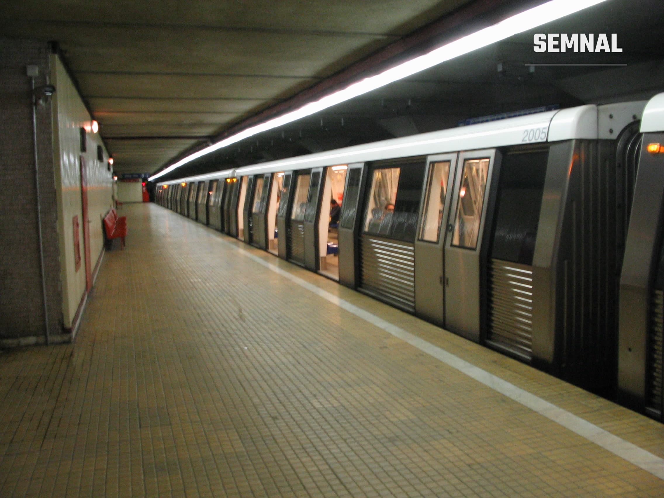Tren de metrou staționat pe peron, într-o stație de metrou din București