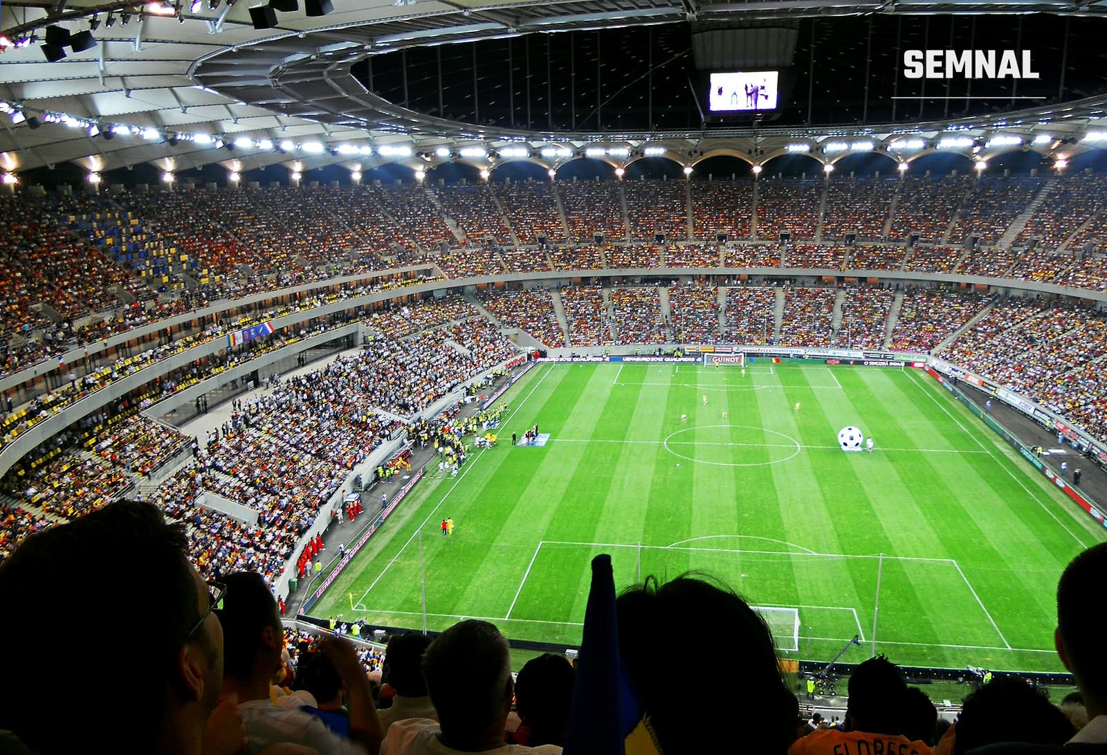 Interiorul Arenei Naționale din București, plin cu spectatori, în timpul unui meci de fotbal