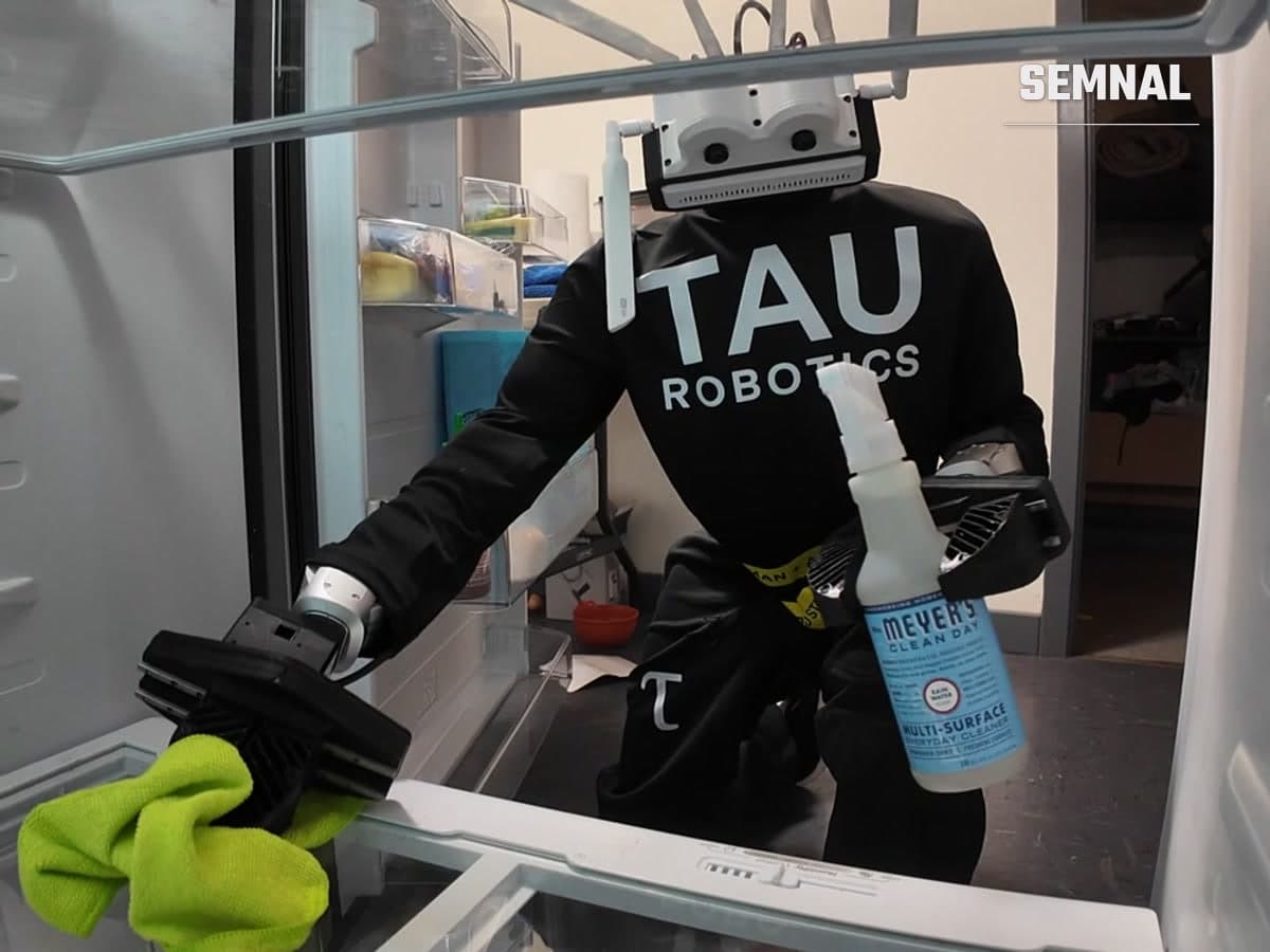Un robot umanoid al Tau Robotics curăță interiorul unui frigider, cu o cârpă și un spray