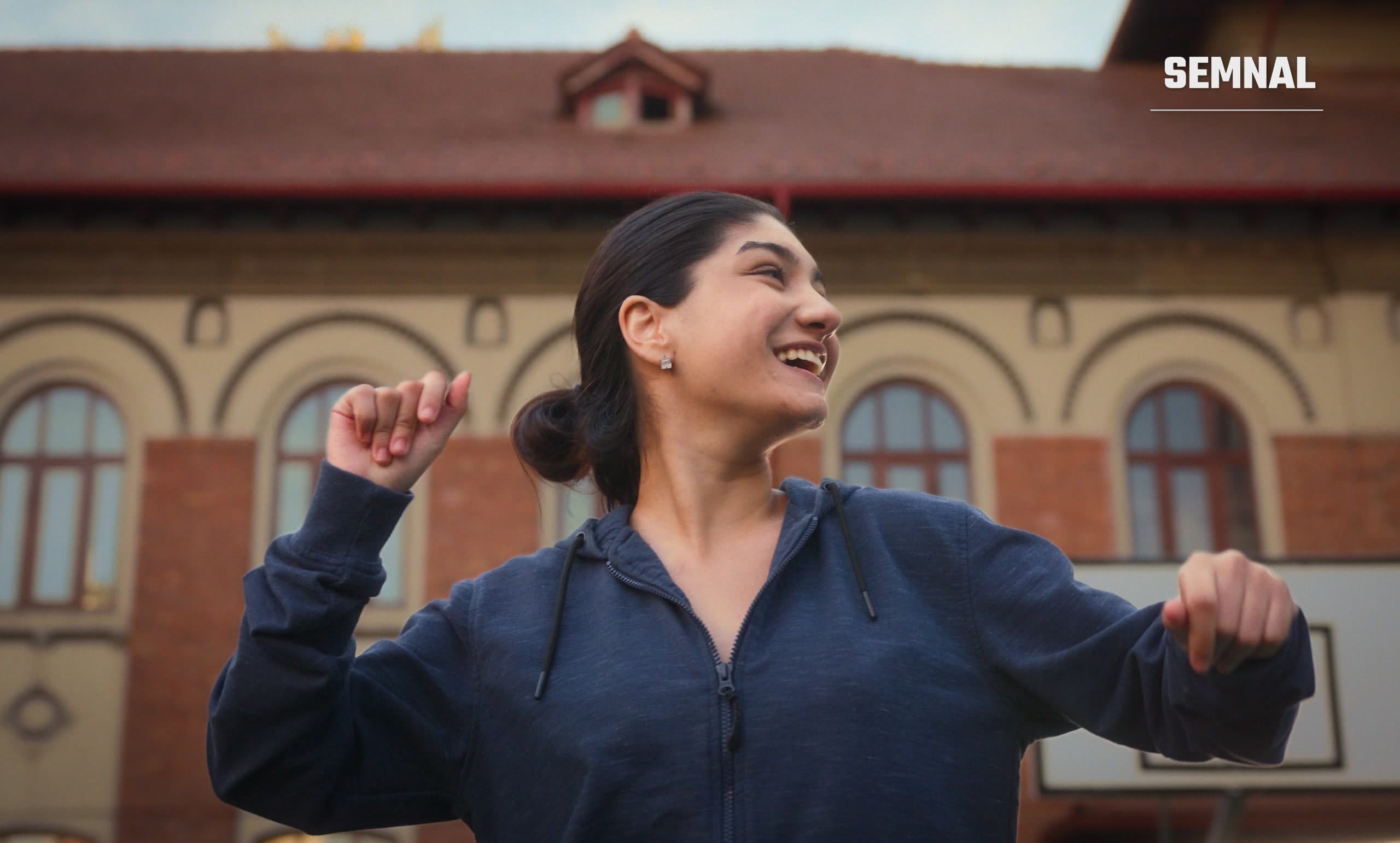 Actrița Raisa Mihai, în rolul Rebecăi, zâmbind și dansând pe o stradă din București, într-o scenă din filmul „Eu contez"