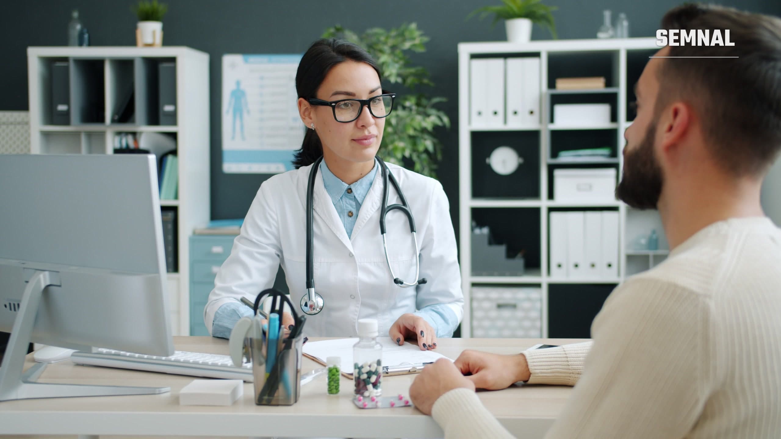 Medic în halat consultă un pacient într-un cabinet modern, discutând despre tratament