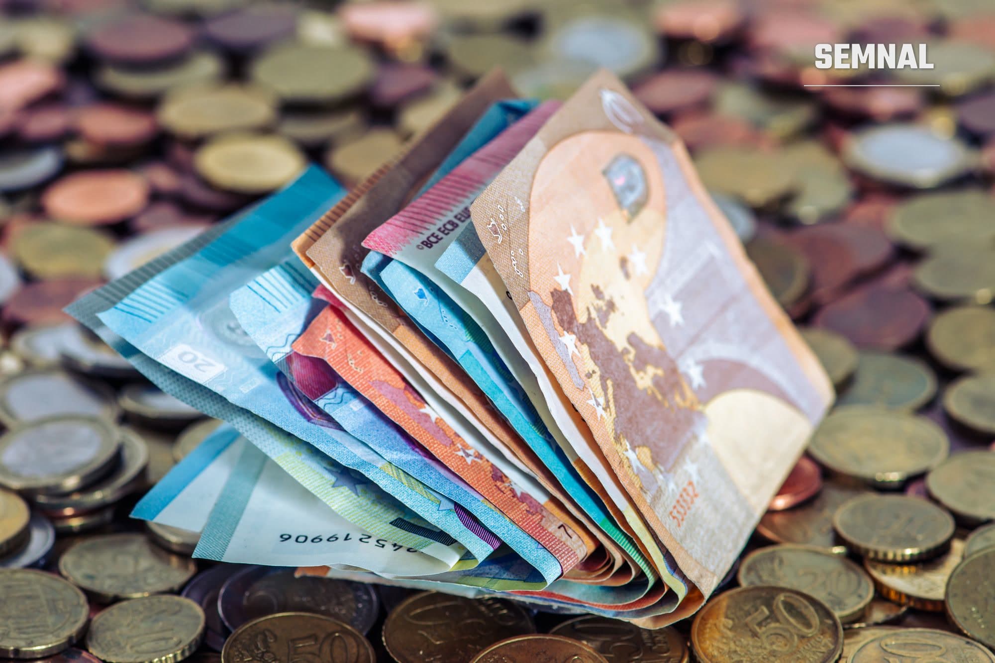 Bancnote și monede euro pe o masă, imagine ilustrativă