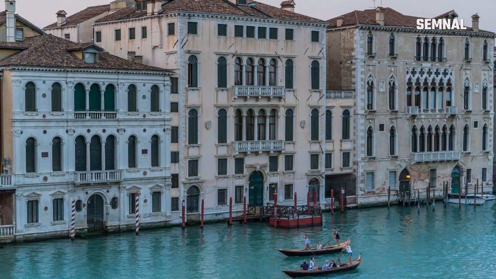 Gondole și clădiri istorice pe un canal din Veneția, Italia, într-o zi însorită