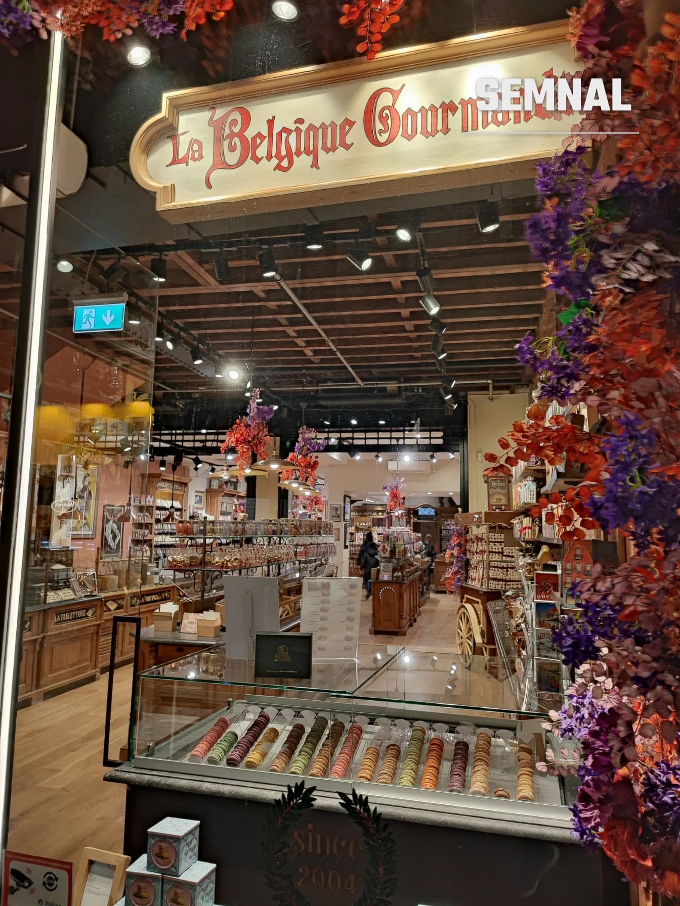 Vitrina magazinului La Belgique Gourmande, cu firma și decor floral