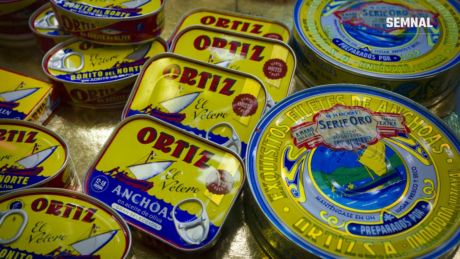 Conserve de ton și de alt pește la vânzare pe o tejghea de piață, produse afișate în cutii metalice colorate