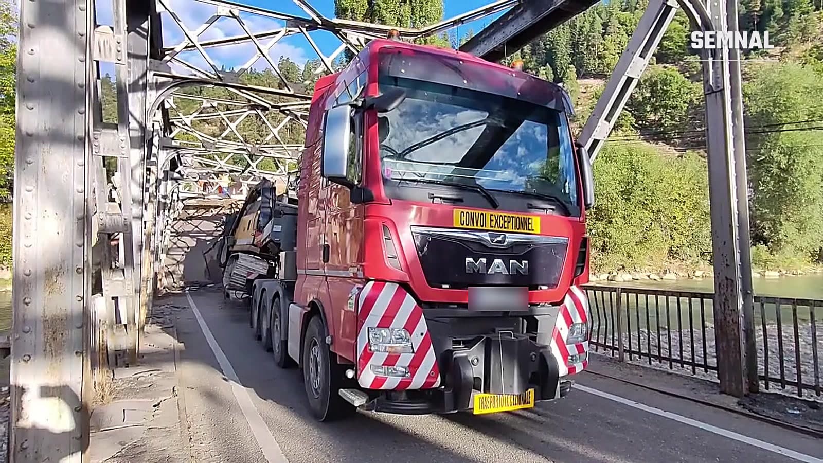 Tractorul unui transport agabaritic oprit pe podul metalic de la Ciobănuș, cu macaraua prinsă în tablierul avariat în spate