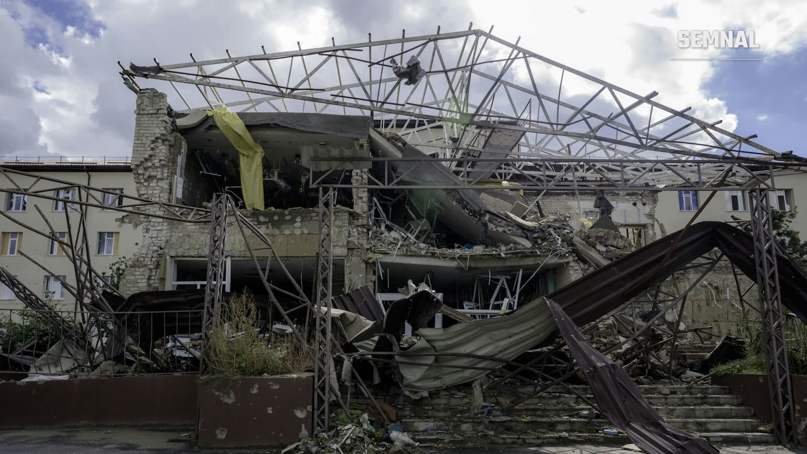 Clădire din Ucraina cu acoperișul metalic prăbușit și fațada distrusă de o explozie, imagine simbol pentru atacurile aeriene rusești asupra clădirilor