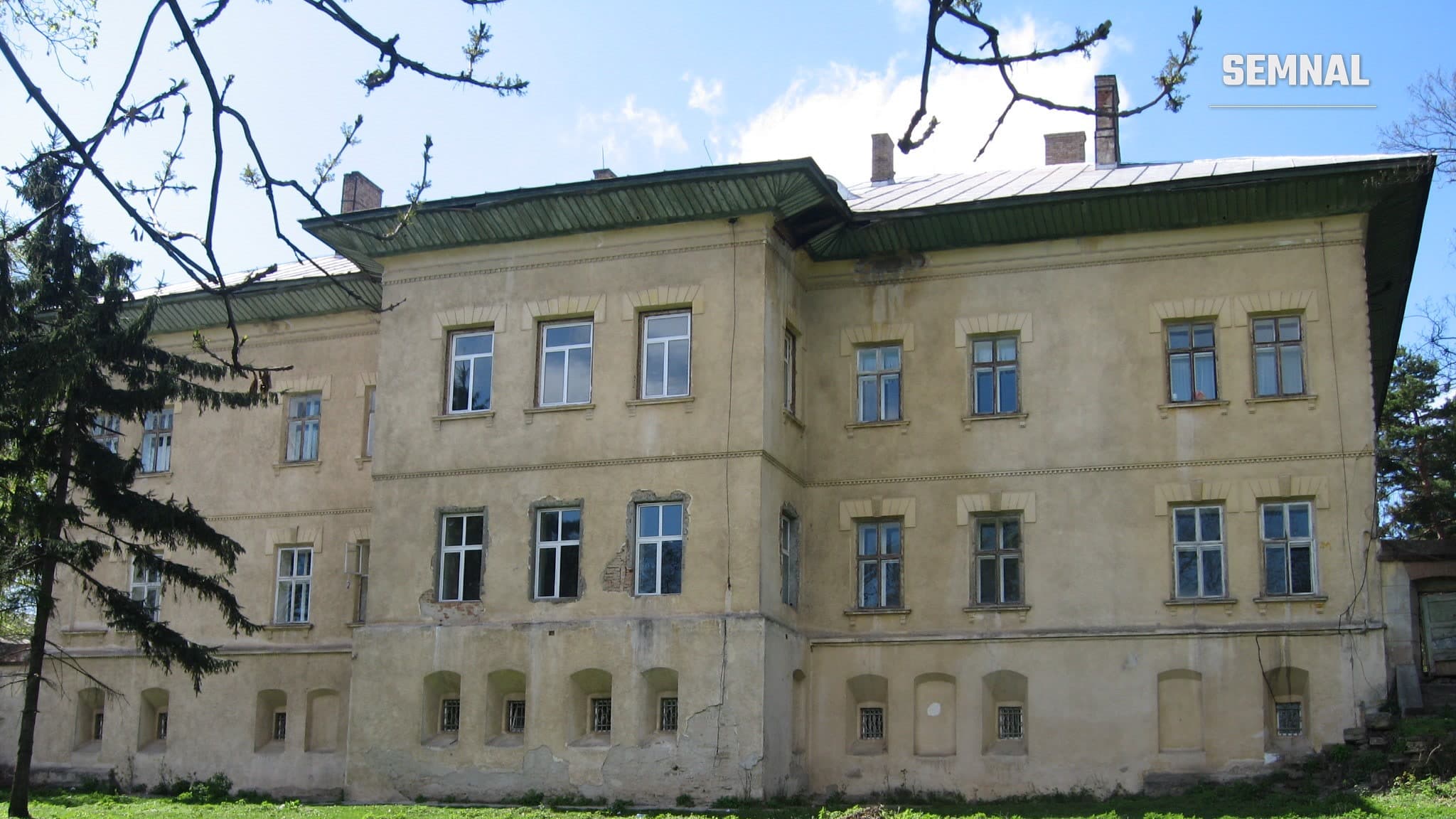 Fațada principală a Castelului Cantacuzino-Ghica din Deleni, județul Iași: clădire cu două etaje, pereți galbeni, ferestre cu ancadramente și streașină verde, văzută de pe peluză