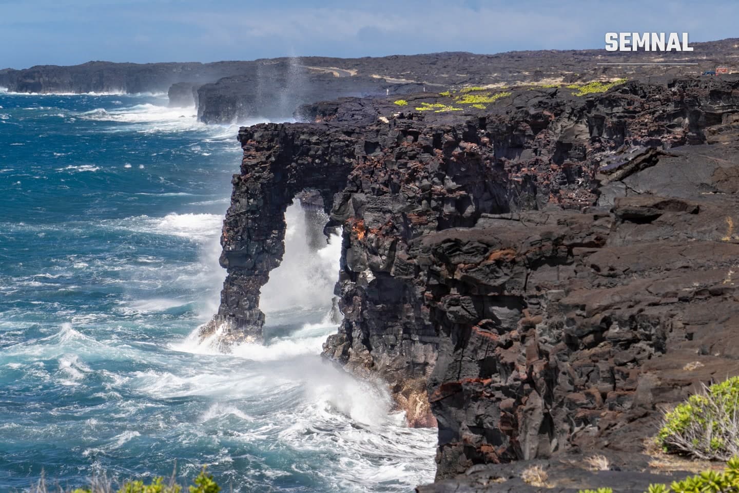 Arcul Hōlei, formațiune de lavă pe coasta Parcului Național Hawaiʻi Volcanoes, lovit de valuri, într-o fotografie din 2022 (NPS/Janice Wei)
