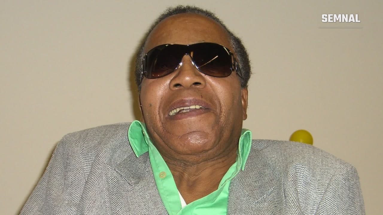 Frank Lucas, fost traficant de heroină din Harlem, cu ochelari de soare și sacou gri, la un eveniment din Manhattan, în noiembrie 2008