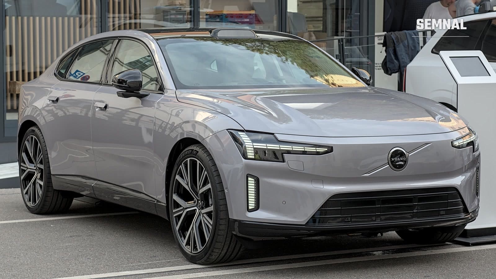 Berlina electrică Volvo ES90, de culoare gri, văzută din față și din lateral, parcată la târgul auto IAA 2025
