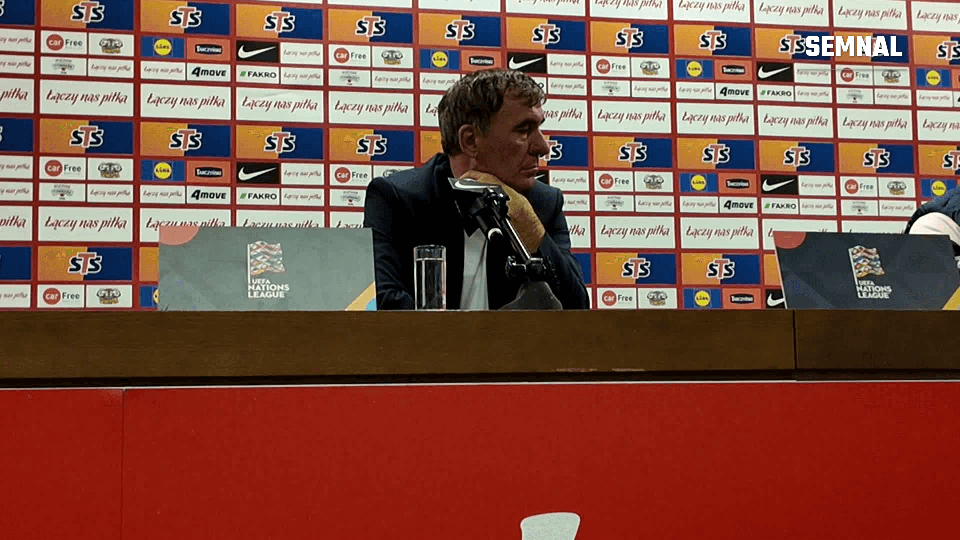 Selecționerul României la masa conferinței de presă de după meciul cu Polonia, în fața panoului cu sponsori al Federației Poloneze de Fotbal