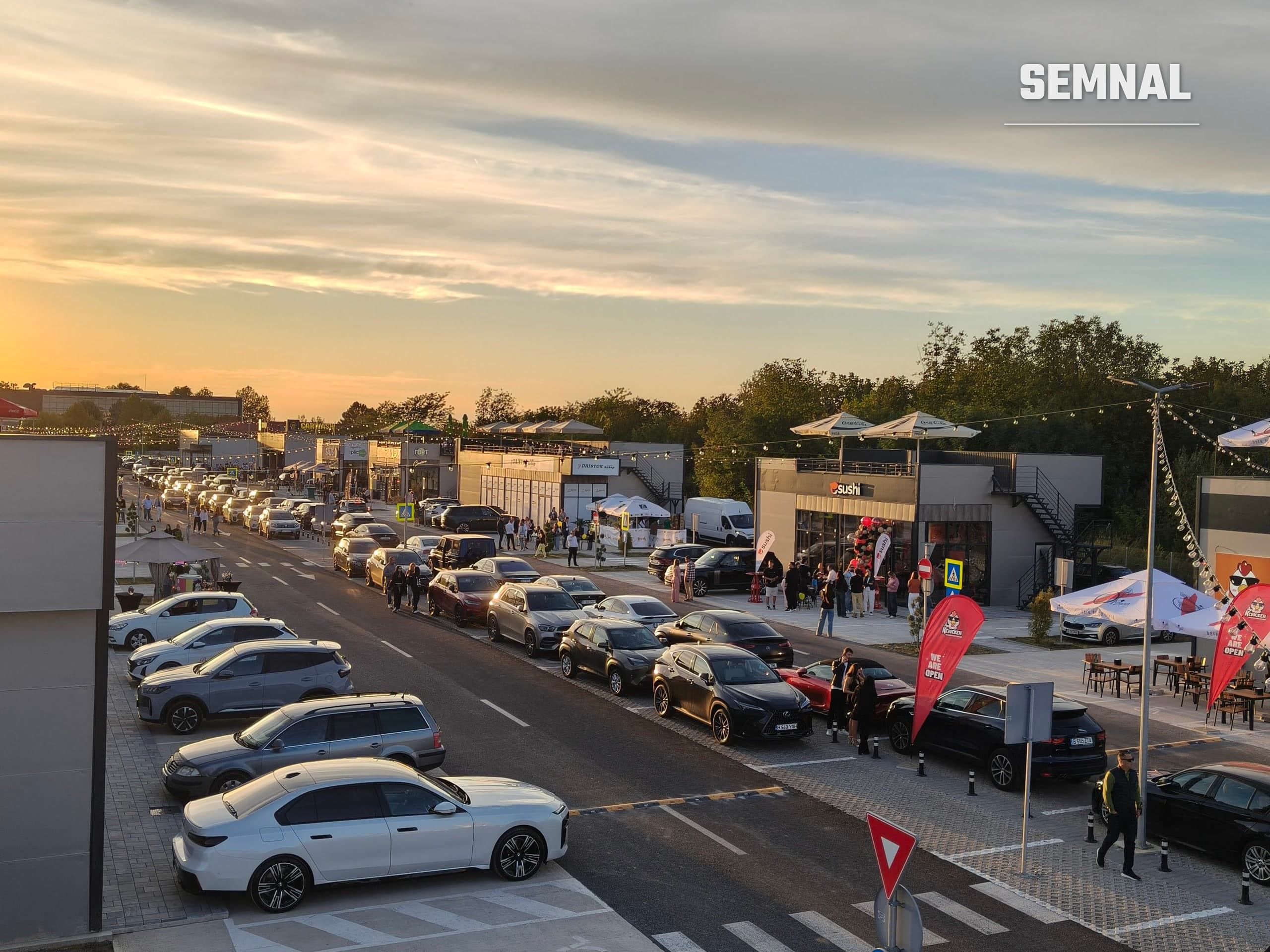 Restaurante cu terase și mașini parcate pe aleea centrală a complexului din Otopeni, în seara inaugurării