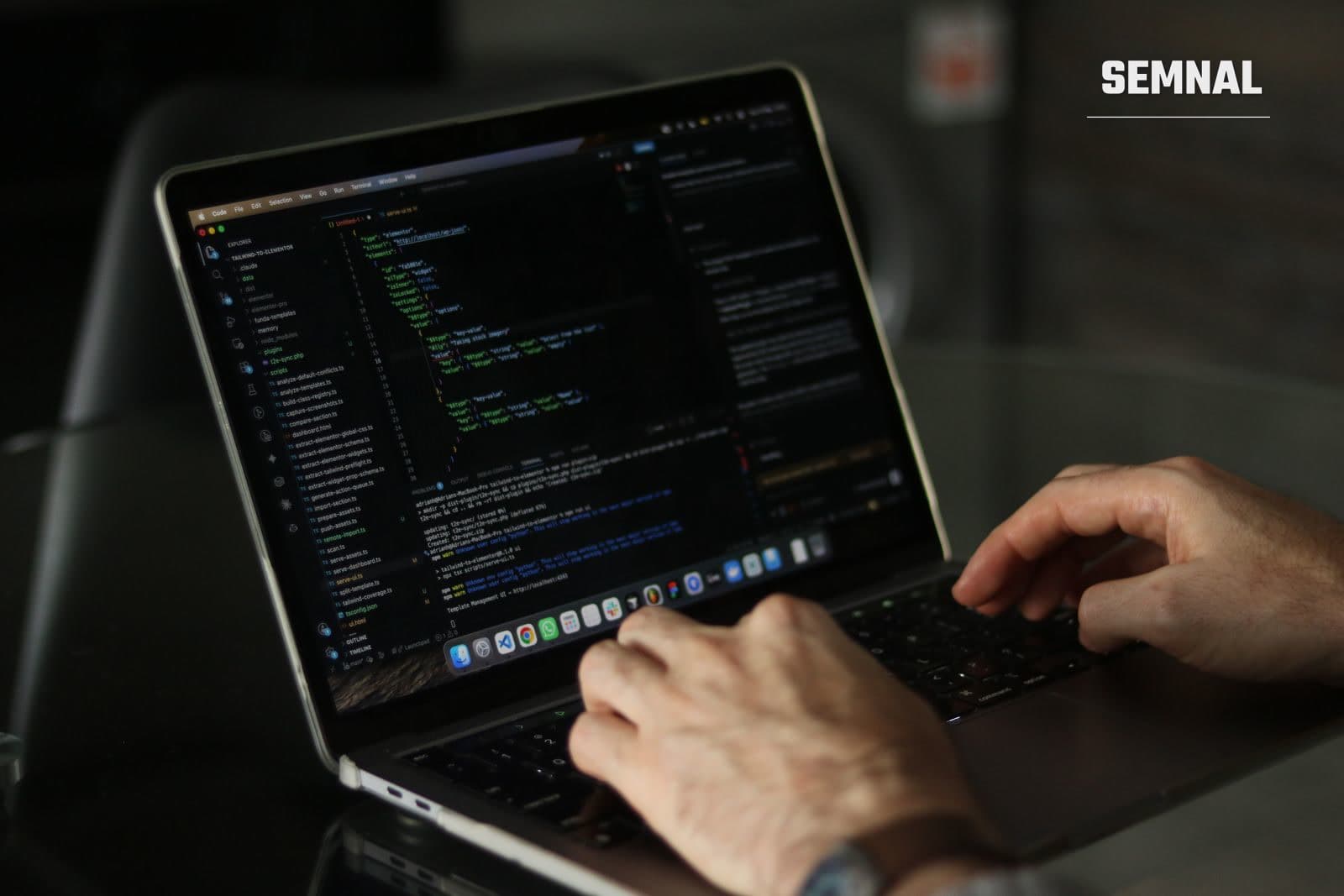 Mâinile unui programator care scriu cod pe un laptop, imagine ilustrativă pentru tehnologie și inteligență artificială