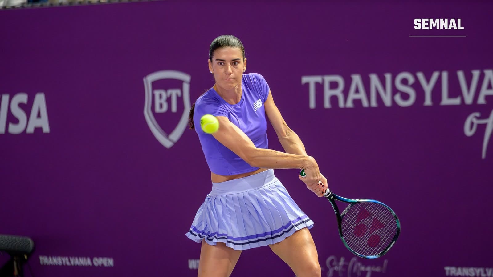 Sorana Cîrstea, în tricou mov și fustă lila, lovește mingea cu rever în fața unui panou mov al turneului Transylvania Open, în februarie 2026