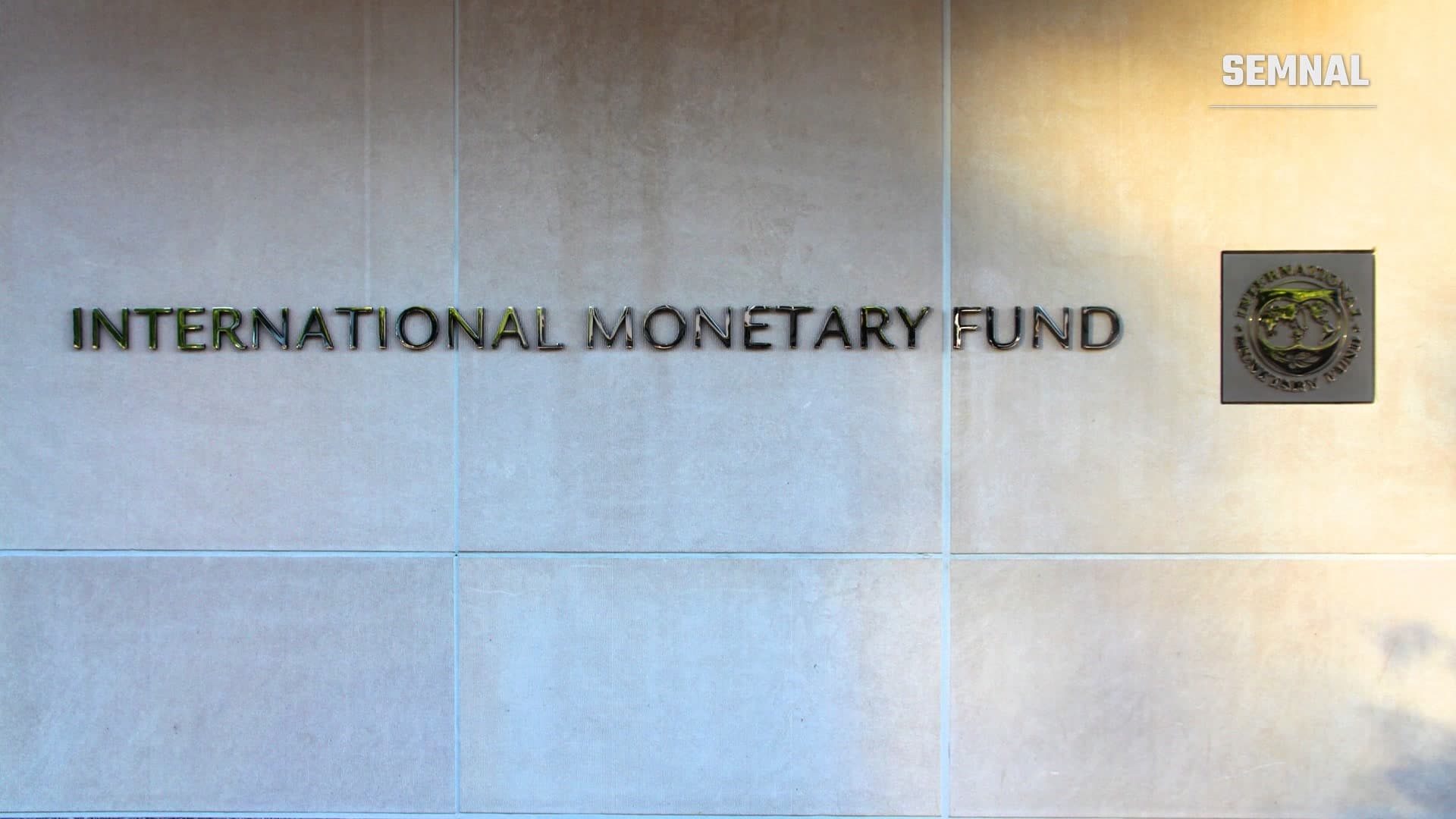 Inscripția „International Monetary Fund” și emblema instituției pe fațada de piatră a sediului FMI din Washington, SUA