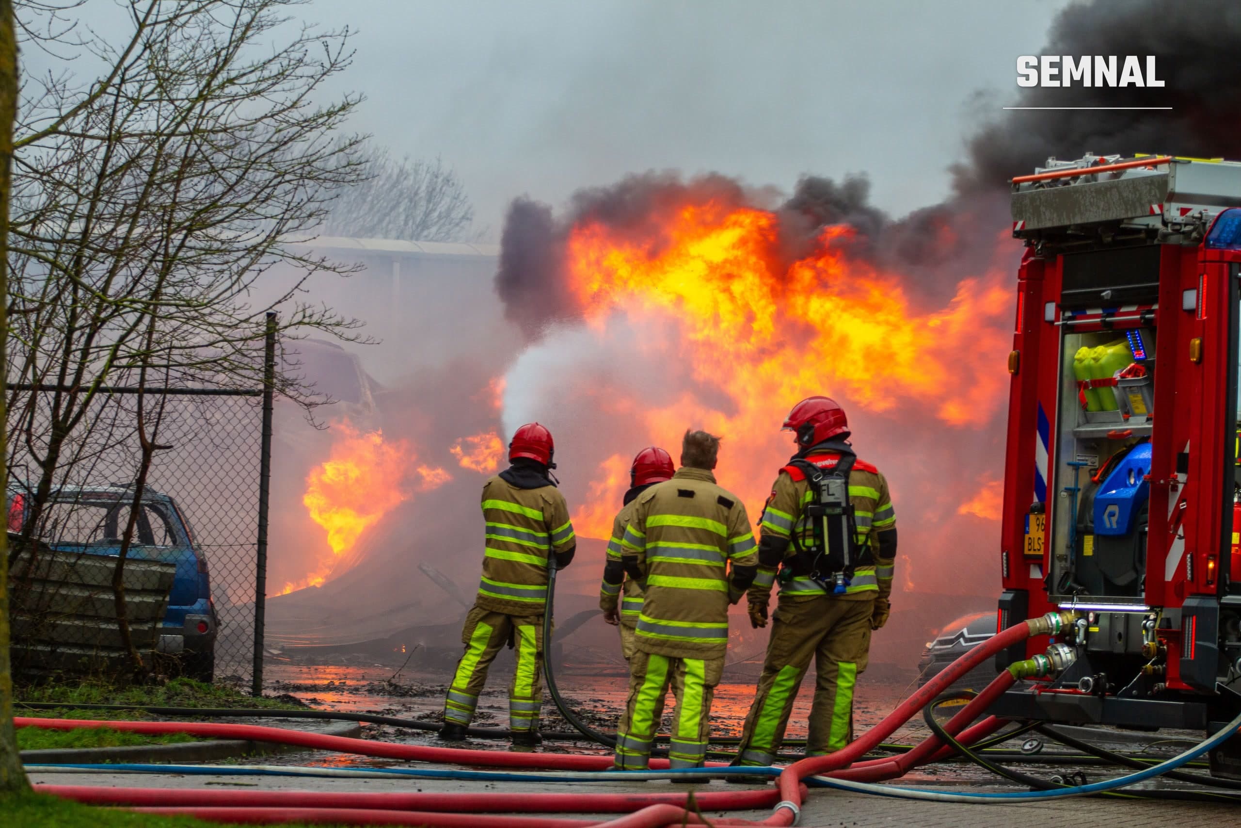 Pompieri intervenind la un incendiu puternic, cu autospecială și furtunuri de incendiu, imagine ilustrativă