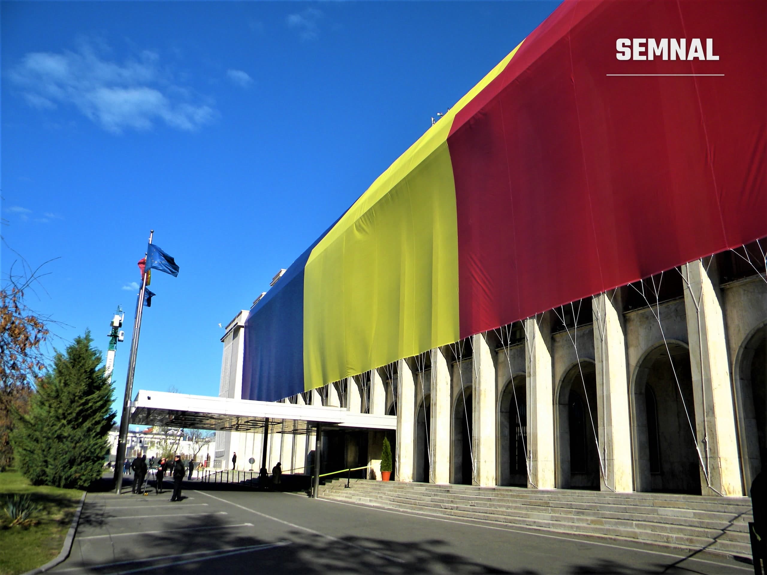 Palatul Victoria, sediul Guvernului României din București, cu fațada acoperită de un drapel tricolor uriaș. Foto: Britchi Mirela / Wikimedia Commons, CC BY-SA 4.0