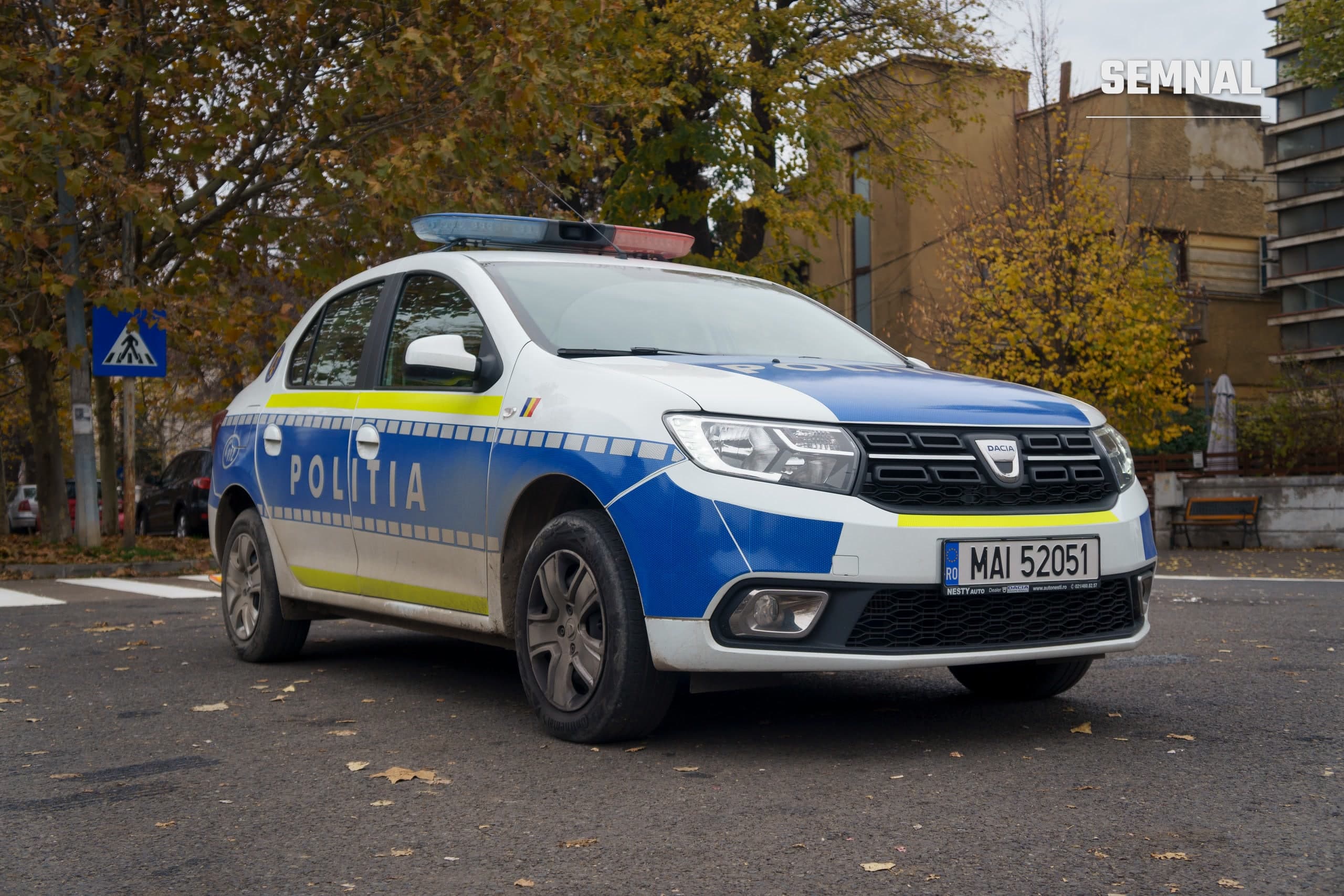 Autoturism Dacia Logan al Poliției Române, în culorile albastru și galben, parcat pe o stradă. Imagine cu rol ilustrativ. Foto: Mihnea Lazăr / Wikimedia Commons, CC BY-SA 4.0