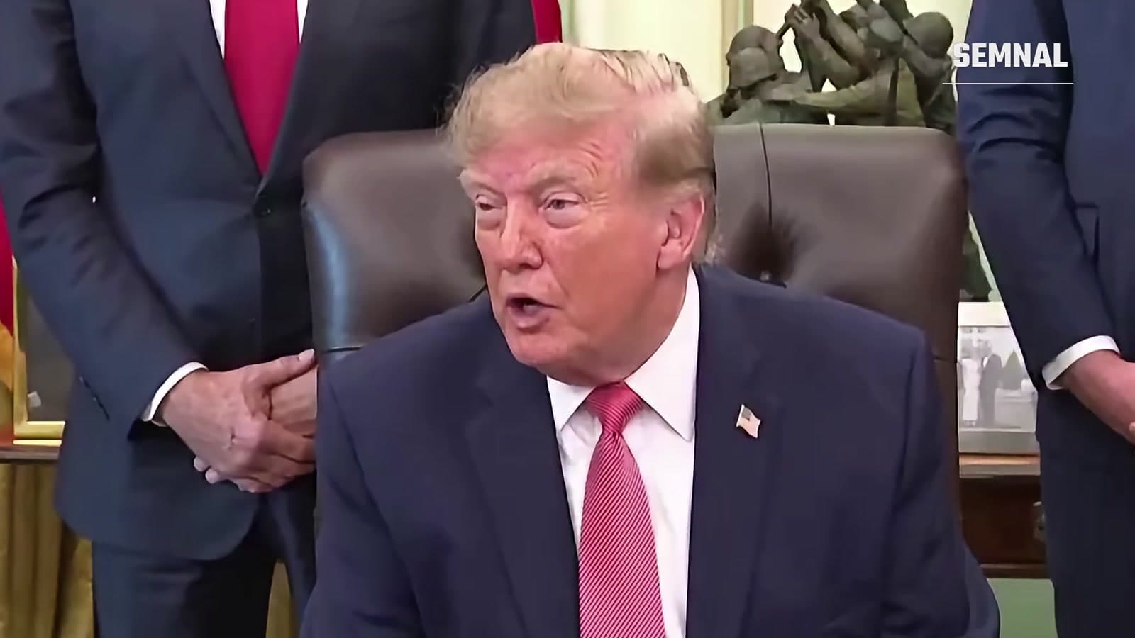 Donald Trump vorbind la biroul din Biroul Oval, cu oficiali în picioare în spatele său, pe 20 octombrie 2026