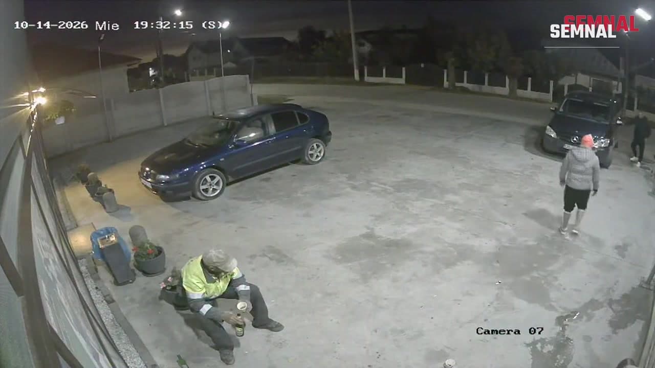 Captură de pe camera de supraveghere: bărbatul de 52 de ani, în vestă reflectorizantă, stă pe o bordură, cu puțin înainte să fie agresat, 14 octombrie 2026