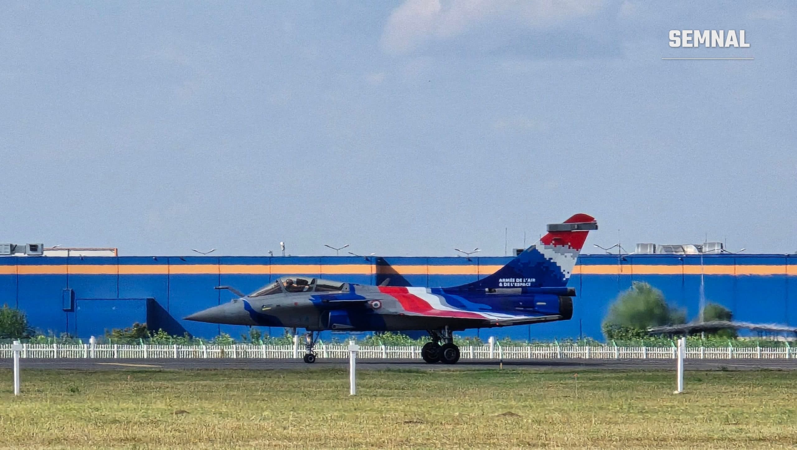 Avion de luptă Rafale al Forțelor Aeriene și Spațiale franceze, în culorile drapelului Franței, pe pista de rulare