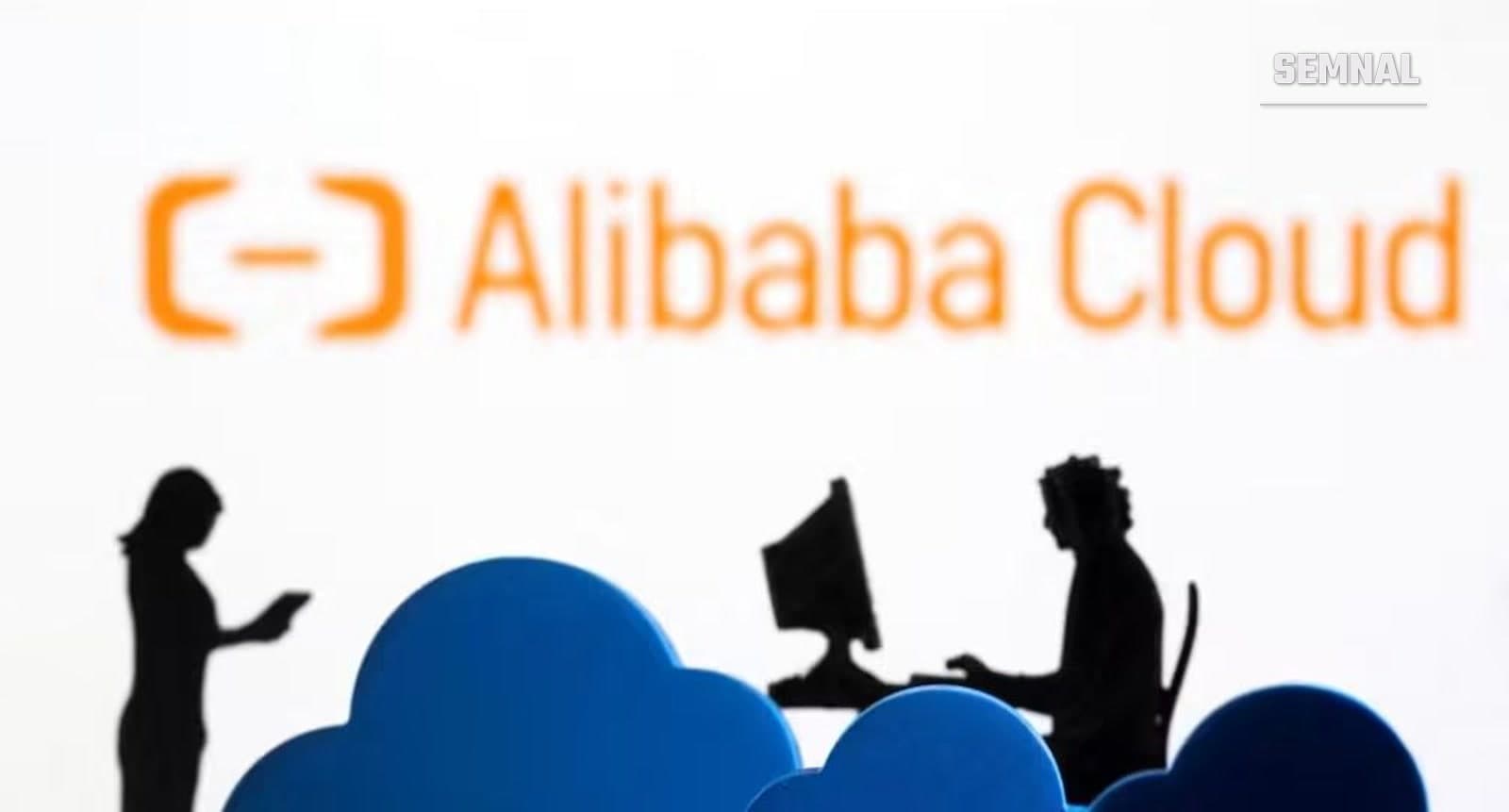 Sigla Alibaba Cloud pe fundal alb, cu siluete de oameni la calculator și nori albaștri în prim-plan
