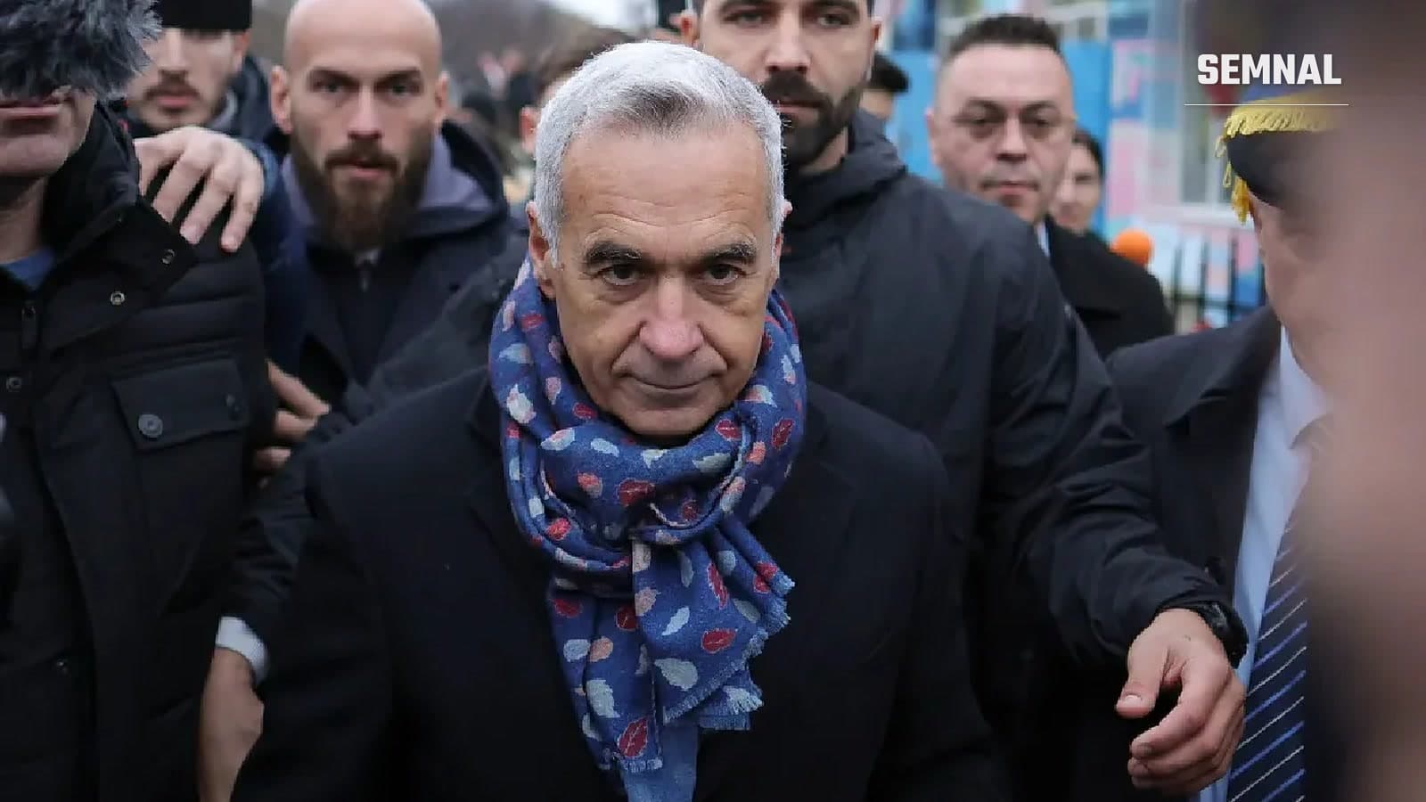 Călin Georgescu, cu fular albastru, înconjurat de oameni la ieșirea dintr-o clădire. Imagine de arhivă. Foto: INQUAM Photos / Octav Ganea