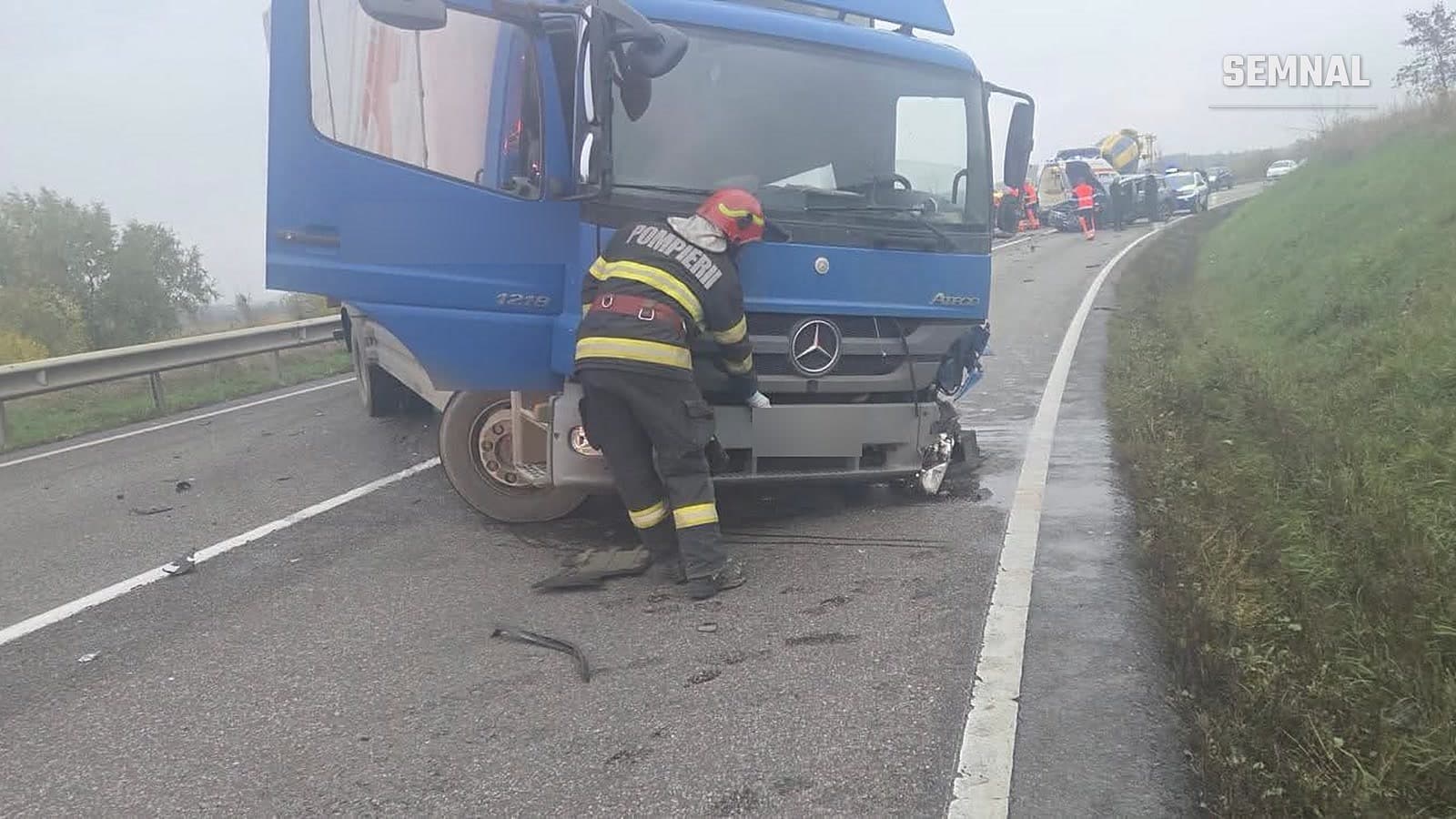 Pompier lângă cabina avariată a unui camion implicat într-un accident pe E85, la Bunești