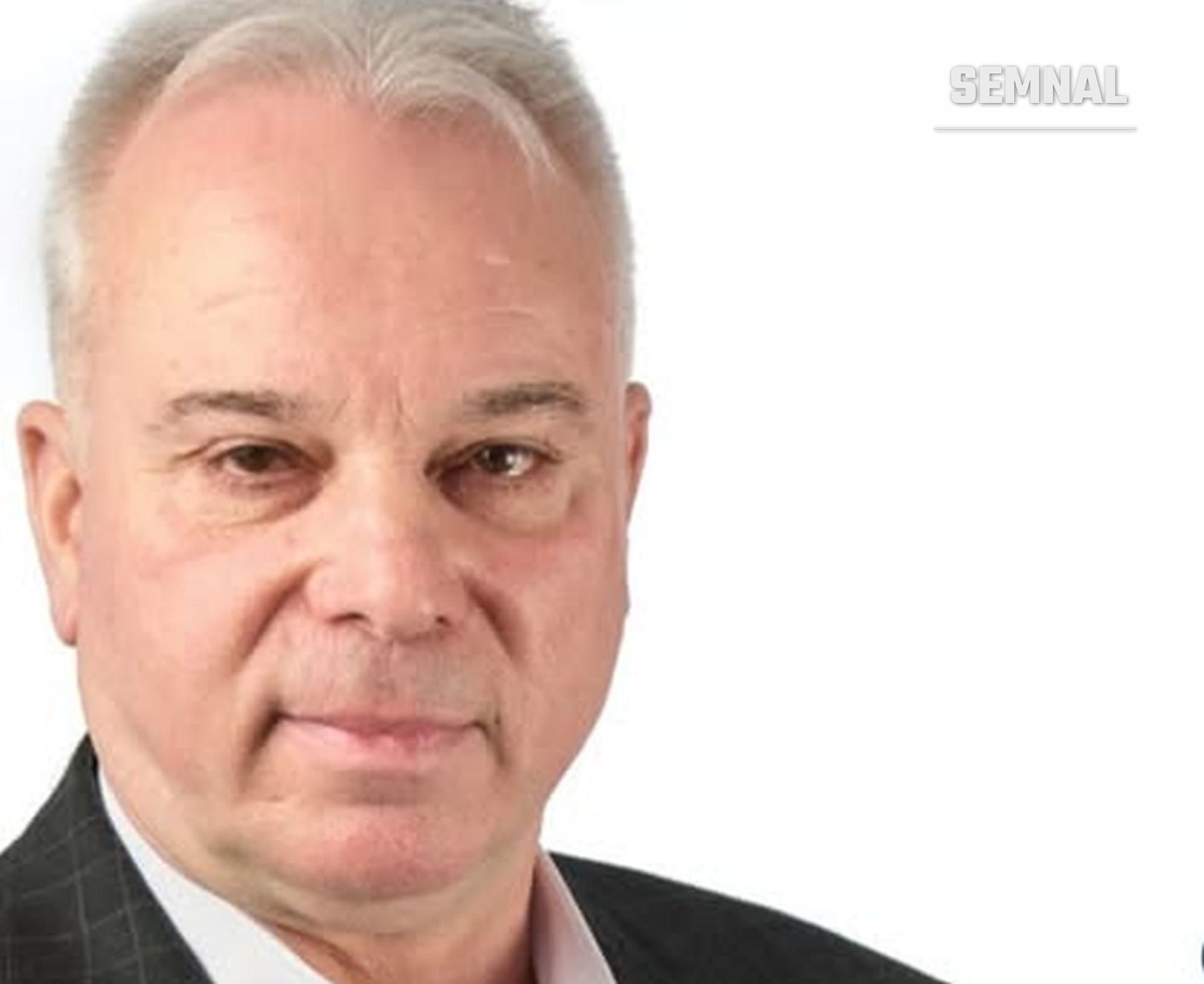 Benone Moraru, primarul orașului Slănic Moldova, într-un portret, îmbrăcat în costum, pe fundal alb