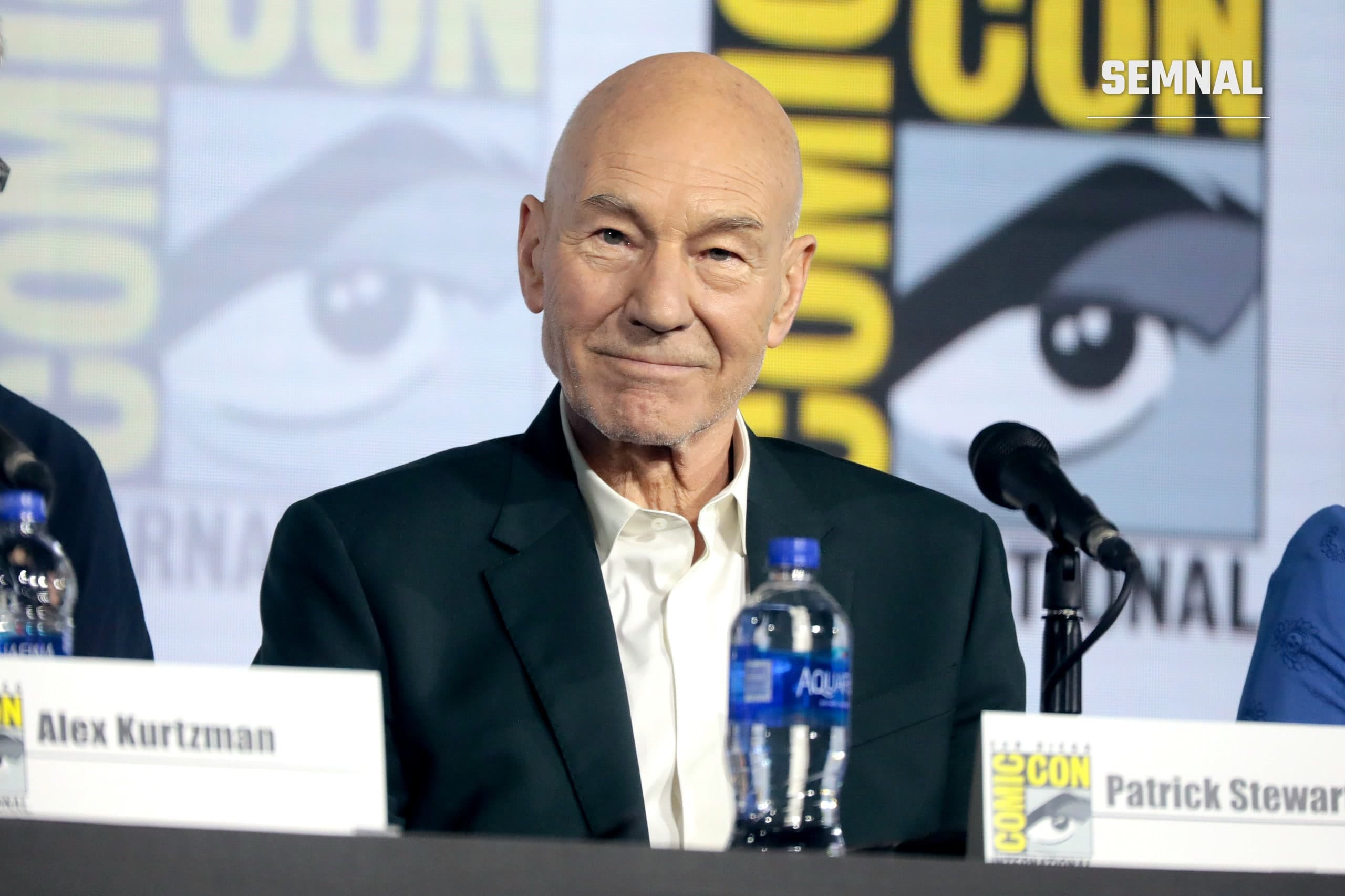Patrick Stewart zâmbește la un panel dedicat serialului Star Trek: Picard, la San Diego Comic-Con 2019, în fața unei plăcuțe cu numele său