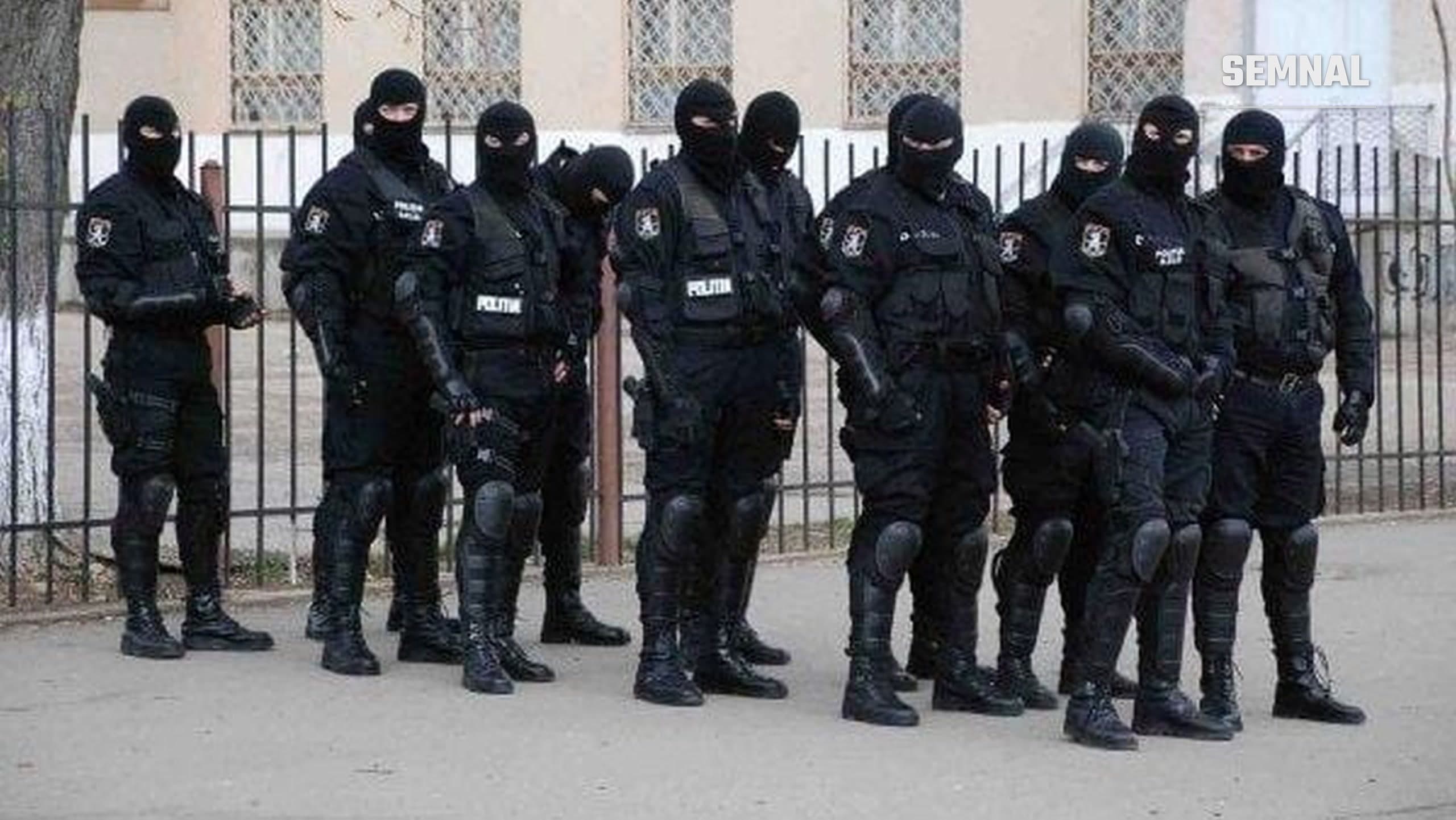 În imagine sunt polițiști care fac perchezitii