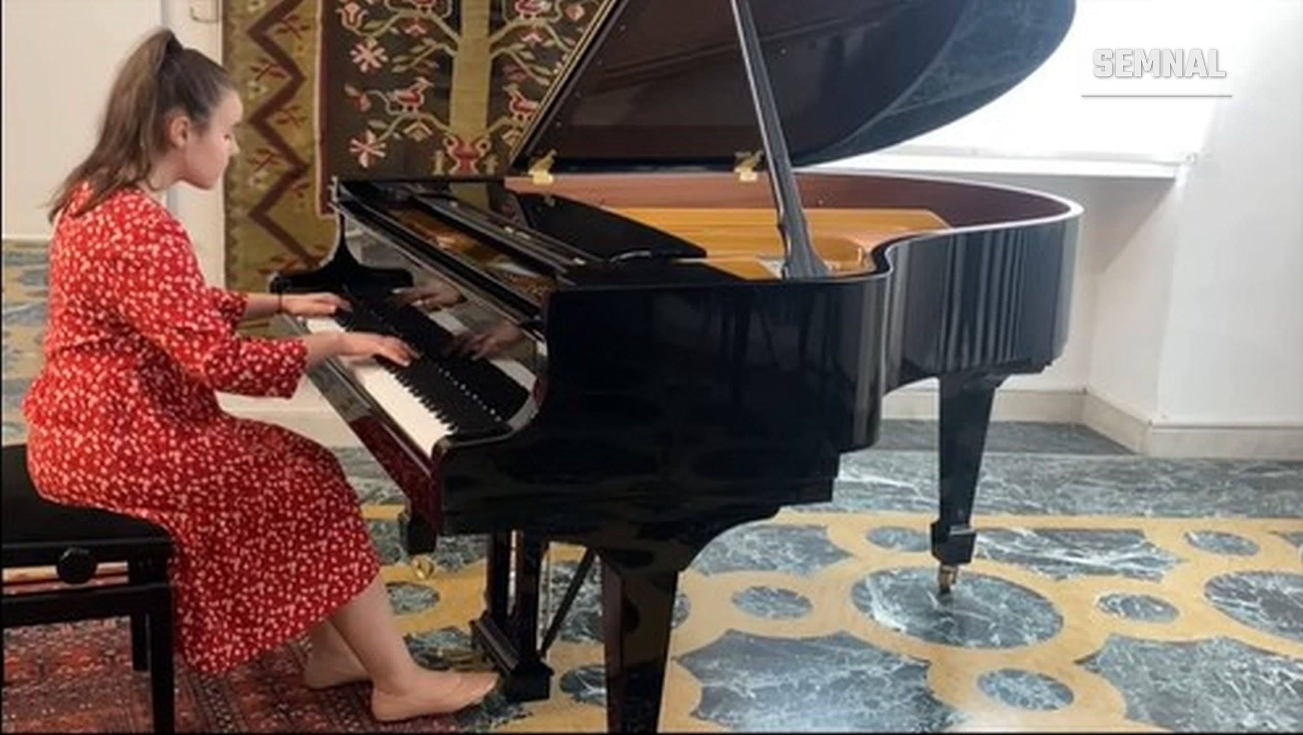 In imagine este pianista Antonia Tașu interpretând o piesă muzicală la pian.