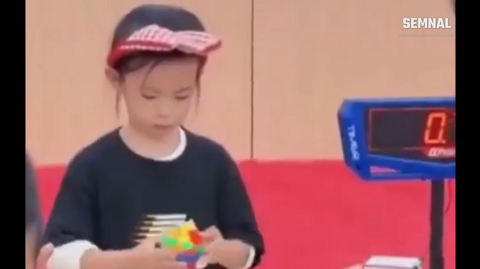 Fetiță jucându-se cu Rubik cub.