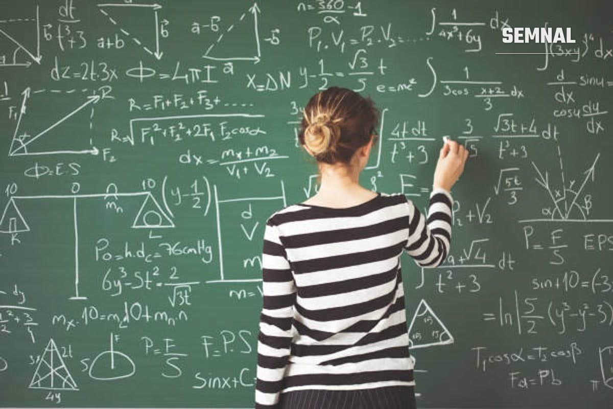 Sală de clasă cu o profesoară care scrie formule matematice.