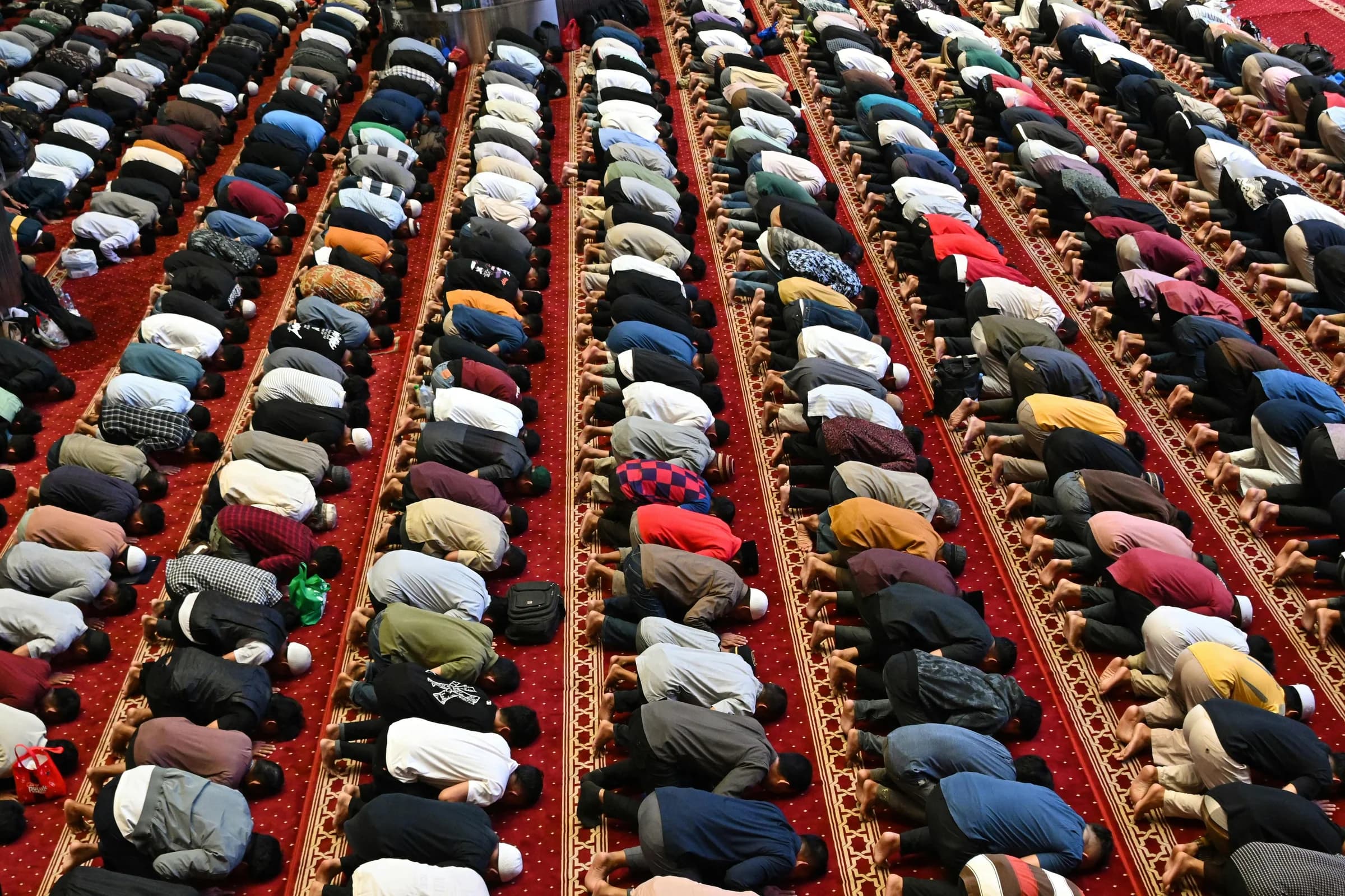 Worshipers in rows performing prayer at a mosque in Jakarta, Indonesia.