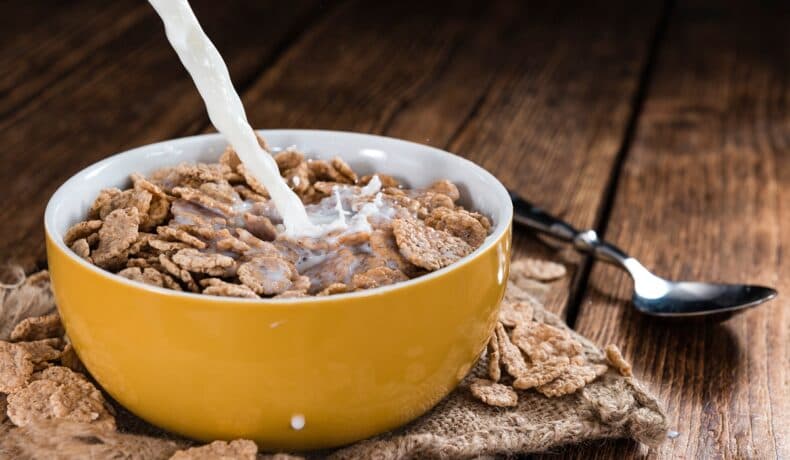 Bowl,with,cornflakes,and,milk,on,an,wooden,table