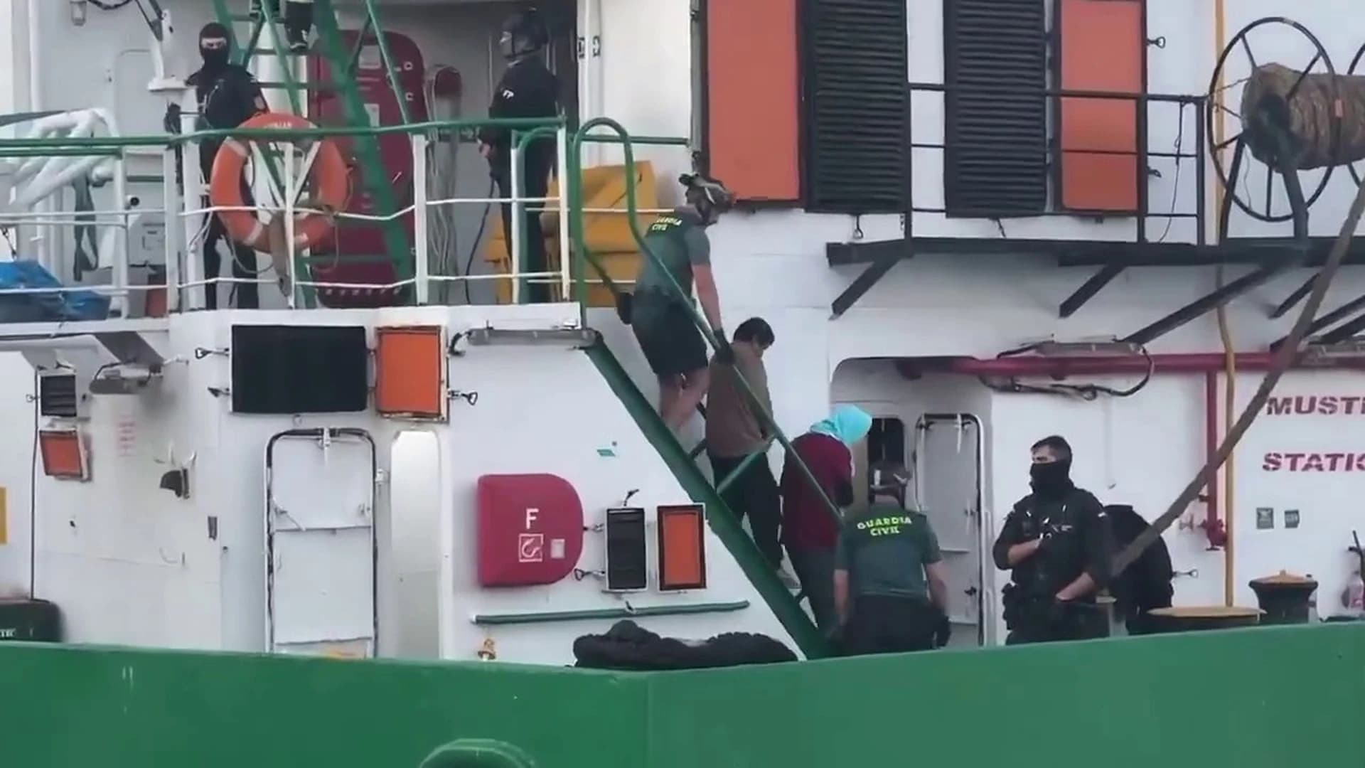 Membri ai echipajului navei Arconian, escortați de ofițeri ai Gărzii Civile spaniole în timpul debarcării în portul Las Palmas